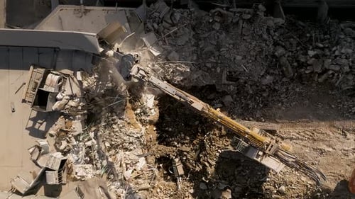 Building demolition excavator using Pulverizer Jaws to demolish a residential building