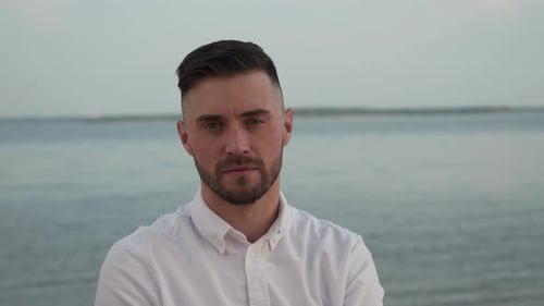 Portrait of Serious Man on Beach with Arms Crossed
