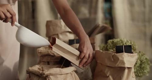Mujer empacando granos para pedidos en línea en Eco Shop