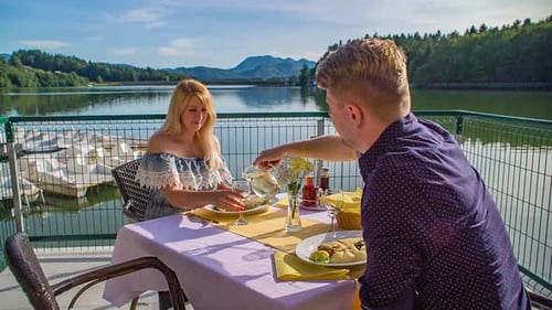 Un jeune couple prend un repas romantique sur les rives du lac Smartinsko, en Slovénie