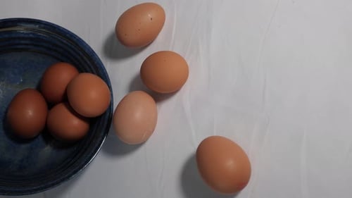 Hen's eggs and a blue bowl - perhaps baking ingredients. Slide over to the left.