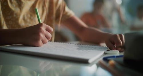 Close Up Shot of Elementary School Girl Writing Exam or Doing Task in Notebook