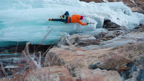 Ice Climber Ascends Frozen Waterfall in Winter