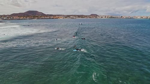 Surfers on sea waves during a cloudy day