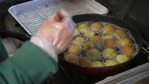 Cooking Falafel Balls With Chopsticks In Hot Oil