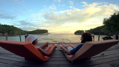 Couple, drink and lounger for relaxing on vacation, tropical and holiday for adventure in Thailand