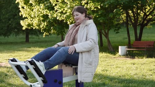 Woman Exercises Outdoors on Leg Press Machine