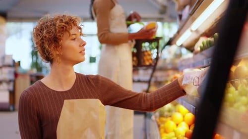 Young Woman Choosing Fresh Fruits at a Grocery Store