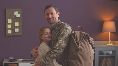 Soldier Hugs Woman in Bedroom