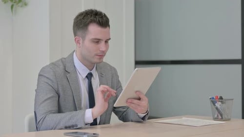 Young Adult Working With Tablet Celebrates Achievement