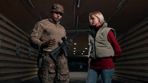 Firearm Instructor Shows Woman Automatic Rifle in Range