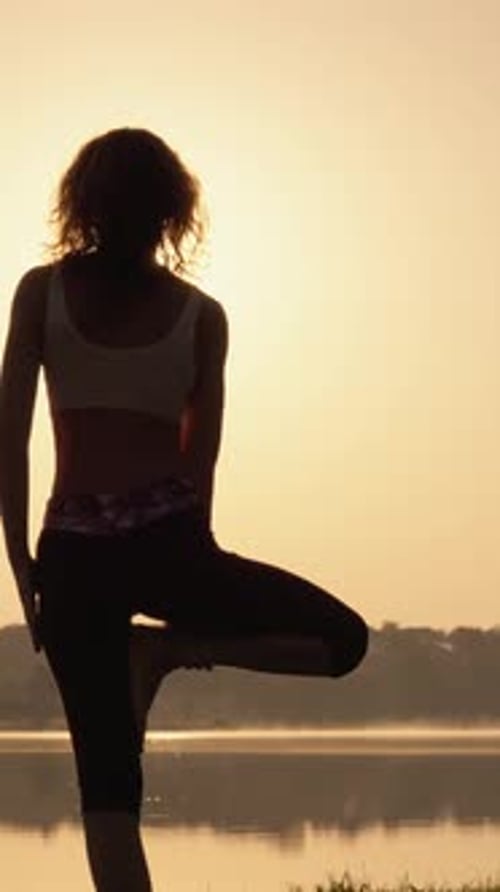 Découvrez la tranquillité d'un yoga serein au lever du soleil au bord du lac, où une séquence de yoga gracieuse émerge