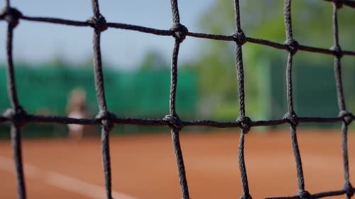 The Essence of Tennis is Captured in a Closeup of a Tennis Net on a Clay Court