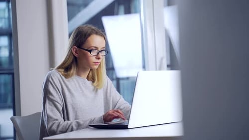 Woman Typing on Laptop at Desk
