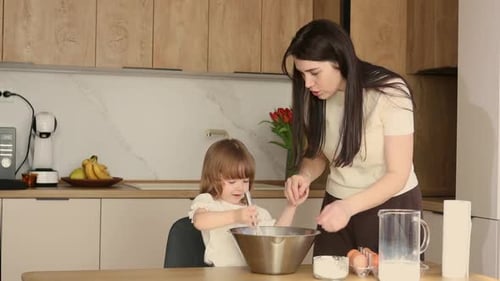 Woman and Girl Mixing Batter in Kitchen