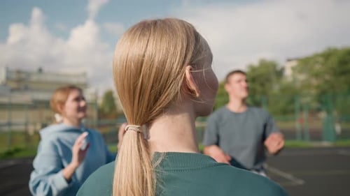 Back View of Lady in Green Hoodie Training Volleyball with Team