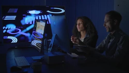 Business Colleagues Reviewing Data in Dark Office