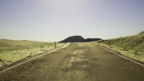 Road Climbs Upward Path Leading to Shadowy Hills Under Pale Sky