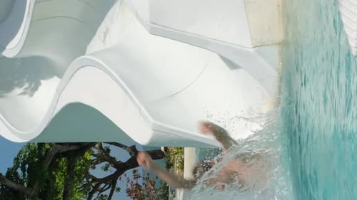 Father with Little Daughter Riding Water Slide