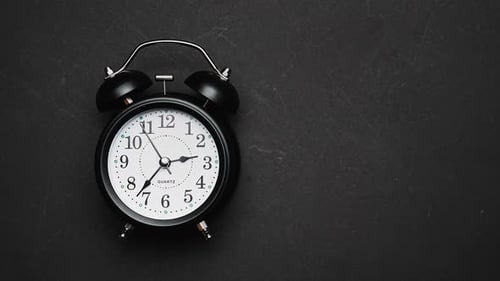 Alarm Clock on Dark Background Speeding Up Time