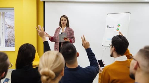 Business Woman Coach Trainer Presents a Report Shows Diagrams on Flip Chart in Conference Hall