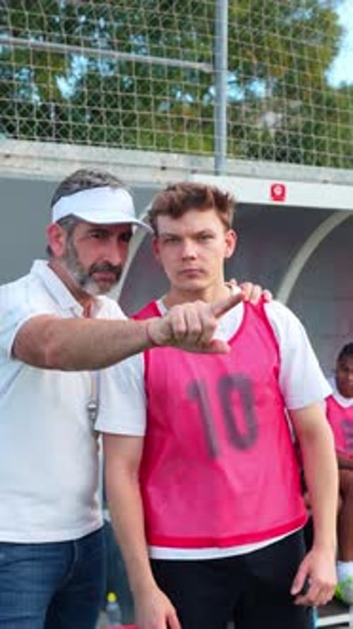 Soccer Coach Giving Instructions to Young Player