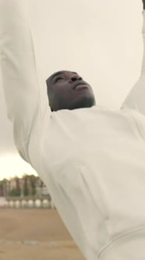 Man doing pull-ups on a horizontal bar outdoors