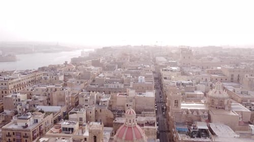 Drone rising high above the old town of Valletta Malta on a hazy day
