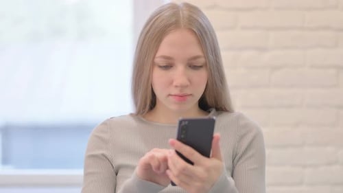 Upset Woman Looking at Cell Phone