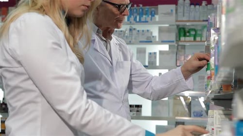 Deux pharmaciens font l'inventaire des médicaments à la pharmacie