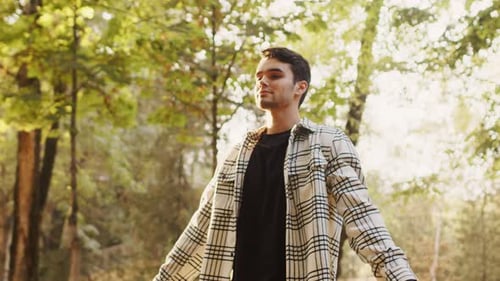Portrait of a Handsome Young Male Standing in Nature Park Outstretched Arms Breathing Deeply During