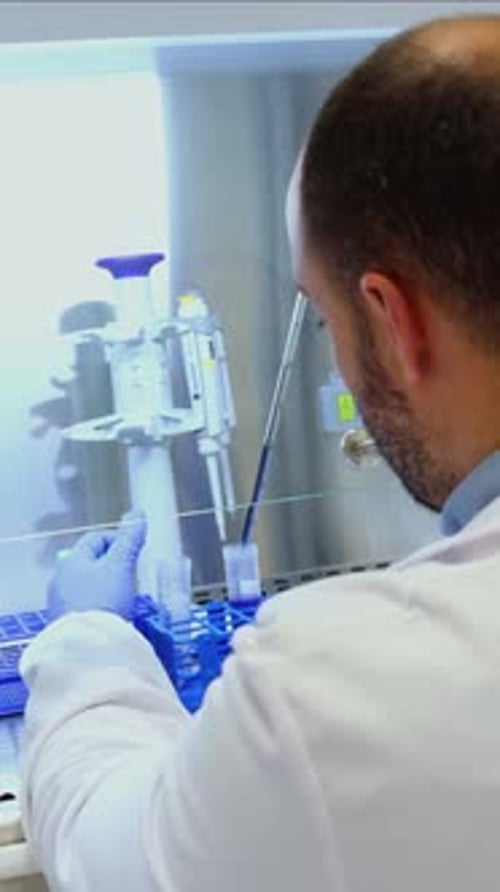 vertikaler Wissenschaftler, der Proben in steriler Laborumgebung analysiert