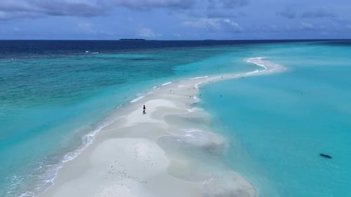 A girl running on a sandbar in the middle of the Indian Ocean