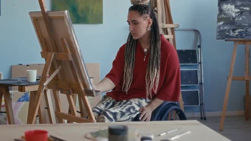 Inspired Female Artist in Wheelchair Painting on Canvas in Studio