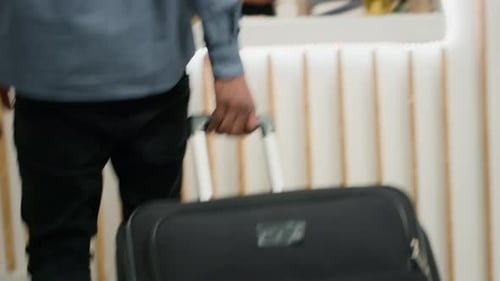 Man Arrives at Hotel Reception with Luggage