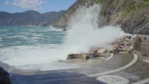 Las fuertes olas chocan contra las rocas de la costa de Italia, creando un espectacular rocío de agua de manantial