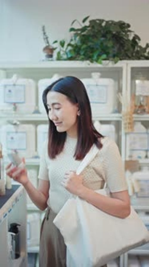Happy woman with a reusable tote bag in a zero waste store