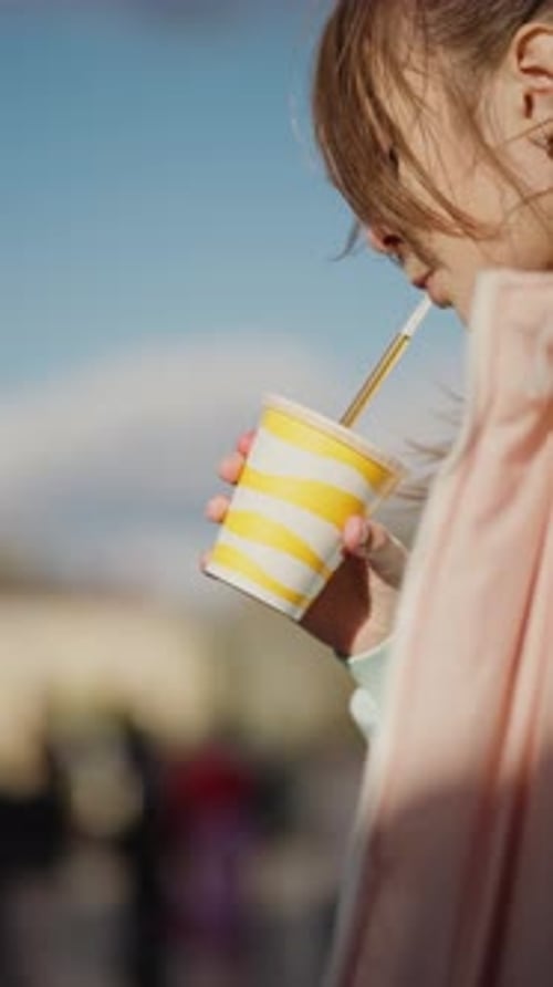 Little Girl Drinking From a Paper Cup Concept of Quenching Thirst