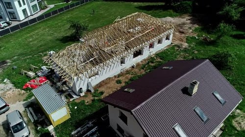 Vue à 360 degrés d'une maison en construction avec charpente en bois pour le toit à proximité d'autres maisons