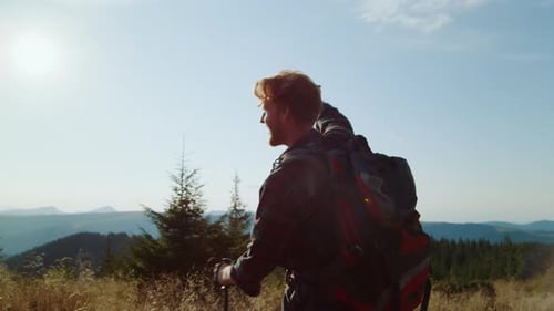 Ginger hiker victoriously raises hands celebrating freedom during mountain hike