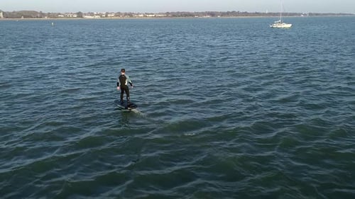 E Foil Sunset boating on the water. Paddleboard, stand-up surfing on electric foil. Aerial drone sho