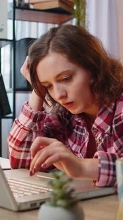 Bored Sleepy Businesswoman Worker Works on Laptop Computer Yawns Leaning on Hand at Home Office Desk