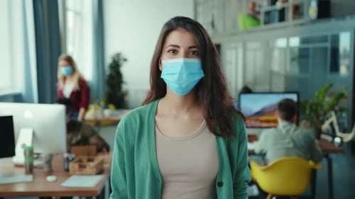 A Young Woman Wearing a Face Mask in a Stylish and Modern Office Workspace Environment