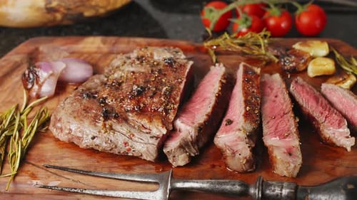 Pedaços de bife de lombo quente servidos na tábua de madeira.