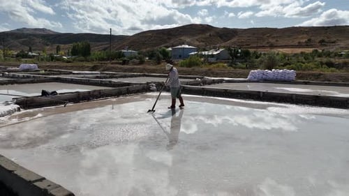 Aerial View Of Worker Working In Salt Ponds