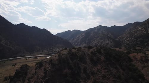 A picturesque road, situated among high rocky mountains. Aerial View.