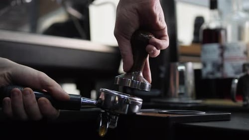 Skilled Barista Presses Ground Coffee with Tamper in Cafe