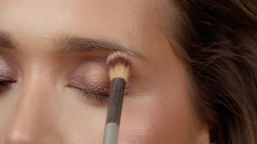 Woman Applying Sparkling Eye Shadow with Brush