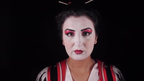 Woman with White Makeup and Red Eyeshadow on Black