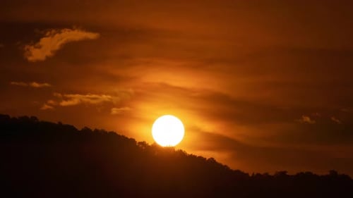 Golden Sunrise Over Dark Silhouetted Landscape